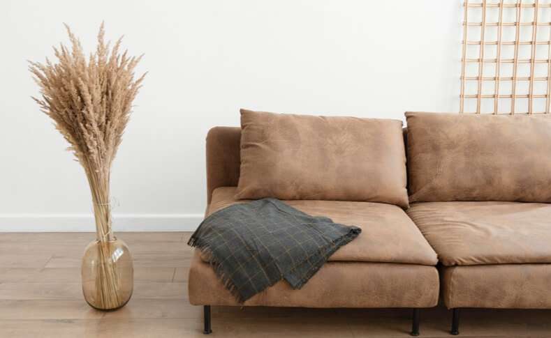 Brown minimal couch with blanket and lamp