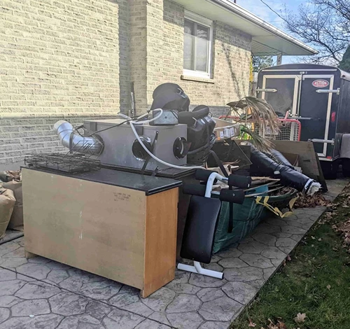 Pile of household junk and furniture in driveway