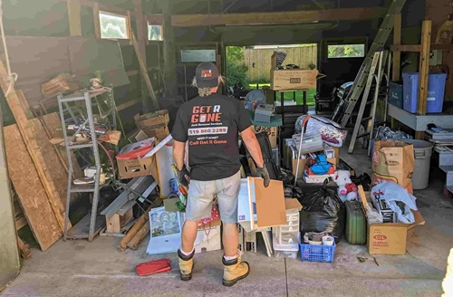 Get R Gone employee emptying garage full of household junk